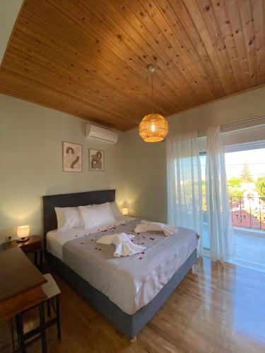 sypialnia z dużym łóżkiem i dużym oknem w obiekcie Searenity Home w mieście Ropanianá