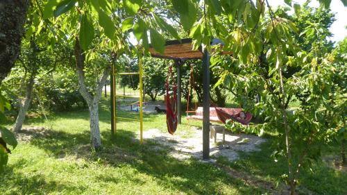 a swing in a garden with a tree at Guest house Pribojska Banja in Pribojska Banja