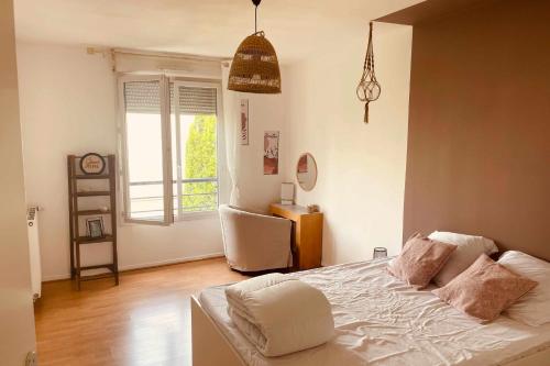 - une chambre avec un lit doté de draps blancs et une fenêtre dans l'établissement Spacious 69 m nest with balcony, à Aubervilliers