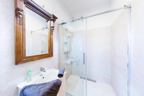 a bathroom with a shower and a sink and a mirror at Bohéme Apartments Charle's Square in Prague