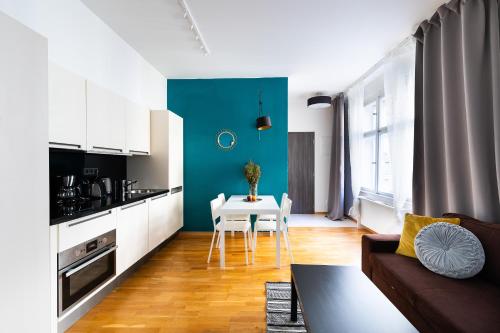 a kitchen and living room with a table and a couch at Bohéme Apartments Charle's Square in Prague