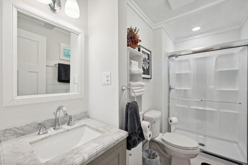 uma casa de banho branca com um lavatório e um WC em Greensboro Golf Getaway - 9 Mi to Downtown! em Greensboro