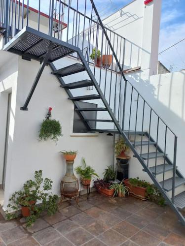 uma escada com vasos de plantas ao lado de um edifício em LOFT EN PATIO DE CASA TÍPICA DE PUEBLO em Villafranca de Córdoba