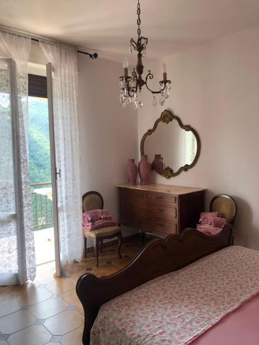 a bedroom with a bed and a mirror and a dresser at Villa ELENA in Mezzanego