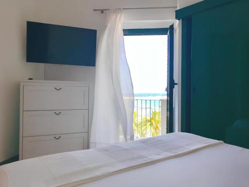 sypialnia z białym łóżkiem i oknem w obiekcie Terrazza Diomede- Manfredi Homes & Villas w mieście Manfredonia