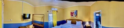 a bedroom with a bed and a tv in a room at Residence Hotel Lux Fairborn - Port Gentil in Port-Gentil