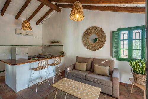 a living room with a couch and a kitchen at Cantueso Holiday Park in Periana