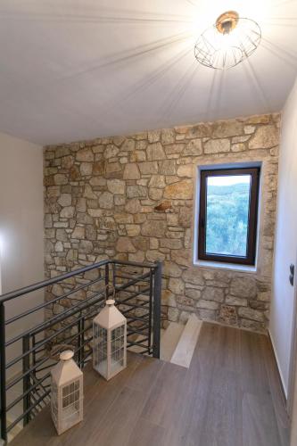 a staircase with a stone wall and a window at Michelangelo suites and apartments in Valanidorachi