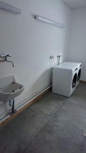 La salle de bains blanche est pourvue d'un lavabo et d'un four micro-ondes. dans l'établissement Bel appartement 4 * + Parking couvert, Résidence Belvédère, à Valmeinier