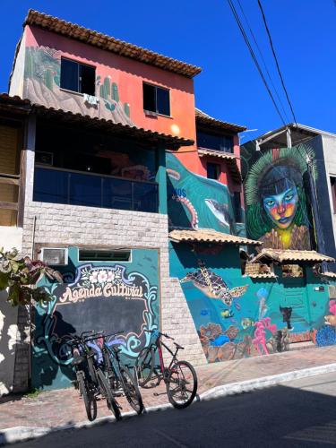two bikes parked in front of a building with a mural at Chamos Hostel Cultural in Arraial do Cabo