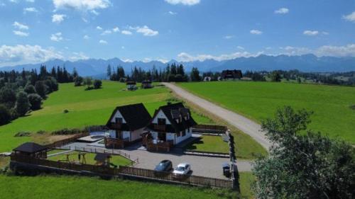 an aerial view of a house in a green field at Domki na Wierchu - z widokiem na góry in Białka Tatrzanska