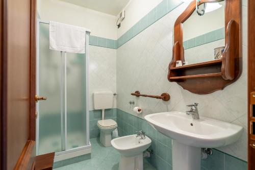 a bathroom with a sink and a toilet and a mirror at Agriturismo Cantine Bevione - Rooms with air conditioning in Belvedere Langhe