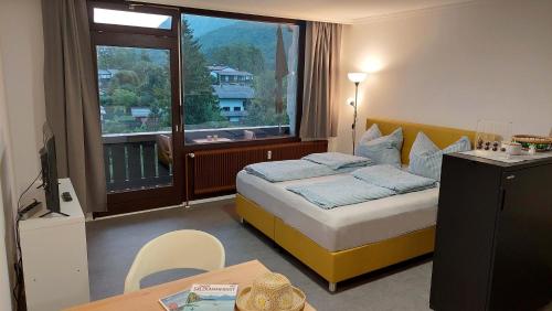 a hotel room with a bed and a large window at Markus Apartment in Strobl