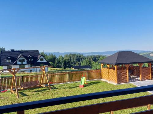 a backyard with a playground with a gazebo at Domki na Wierchu - z widokiem na góry in Białka Tatrzanska