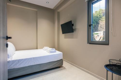 a small bedroom with a bed and a window at Isla Villas & Suites in Balíon