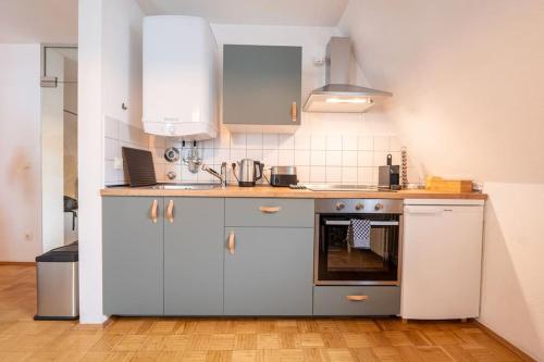 a kitchen with white cabinets and an oven at Loft + Apartment Am Marktplatz mit Disney+ in Chemnitz