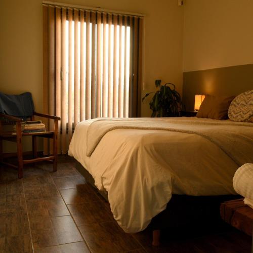 um quarto com uma cama grande e uma janela em Tomero Apartamento em Tupungato