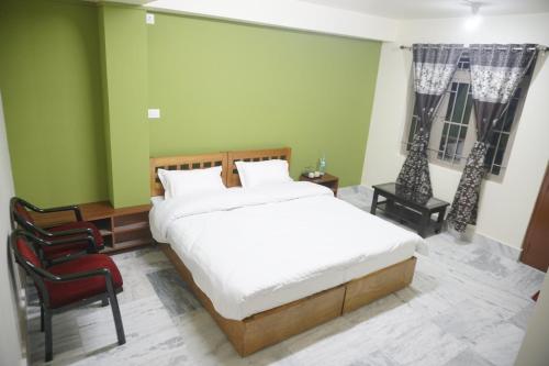 um quarto com uma cama grande e uma cadeira em Miracle Springs Guest House em Shillong