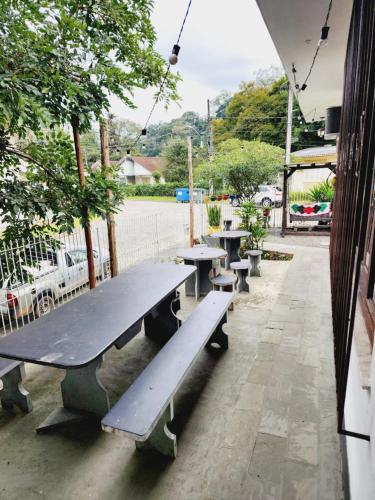 a row of picnic tables on a sidewalk at Hostel Lumaria 1 in Blumenau