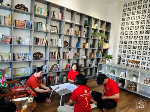 un groupe de personnes assises autour d'une table dans une bibliothèque dans l'établissement Loka Home & Yoga, à Đà Nẵng