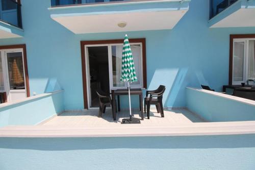a blue building with a table and two chairs at Vera Apart Otel in Marmara