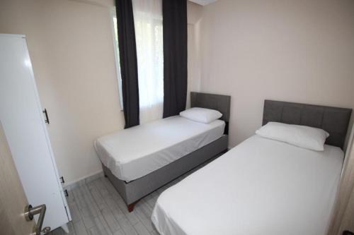 two beds in a small room with a window at Vera Apart Otel in Marmara