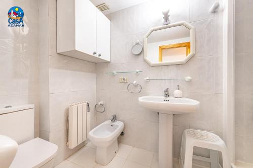 a white bathroom with a sink and a toilet at Apartamentos La Noria Casa Azahar in Alcossebre