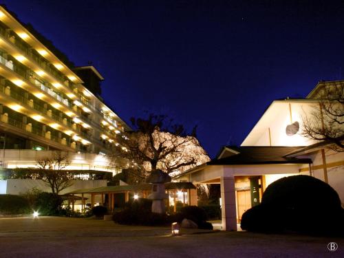 a large building with lights on it at night at Hyoe Koyokaku in Kobe
