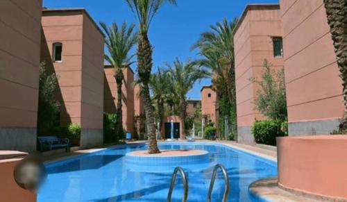 - une piscine avec des palmiers dans un complexe dans l'établissement Riad QAYS, à Marrakech