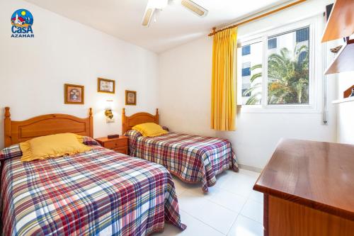 a bedroom with two beds and a window at Apartamentos La Noria Casa Azahar in Alcossebre