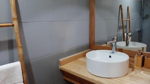 a bathroom with a white sink and a mirror at Nid Kreyol in Sainte-Anne
