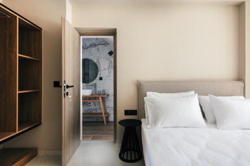 a bedroom with a white bed and a mirror at Isla Villas & Suites in Balíon