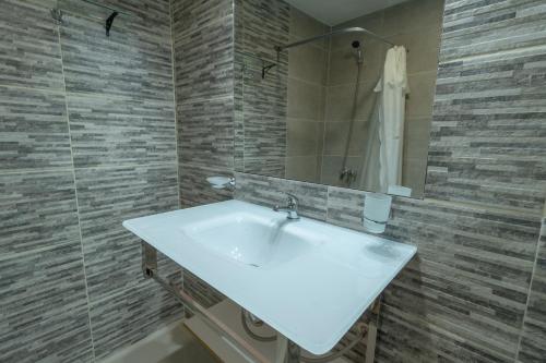 een badkamer met een witte wastafel en een douche bij Cabaña de los Colibríes in Esquel