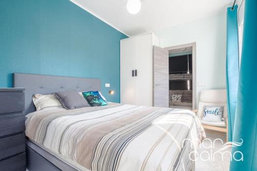 a bedroom with a large bed with a blue wall at Villa Rustical by MarCalma in Bonmont Terres Noves
