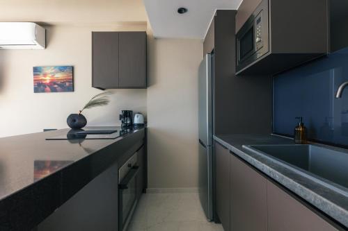 a kitchen with a sink and a refrigerator at Isla Villas & Suites in Balíon