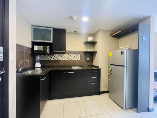 a kitchen with black cabinets and a stainless steel refrigerator at Santa Ana Suite - Bellini 2 in Guayaquil
