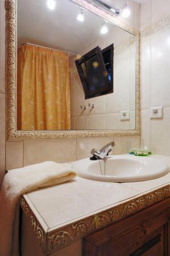 a bathroom with a sink and a tv on a mirror at Castillo Lanzarote Villa Bailey - Luxury Villa - heated Pool in La Asomada