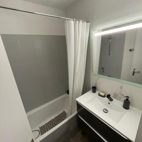 une salle de bain blanche avec un lavabo et une douche dans l'établissement Maison plain pied avec climatisation dans une résidence privée avec piscine, à Saint-Saturnin-lès-Avignon