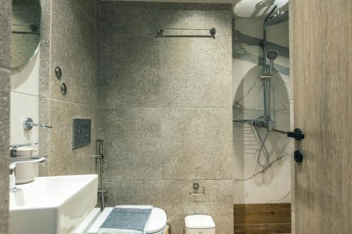 a bathroom with a toilet and a sink and a shower at Isla Villas & Suites in Balíon