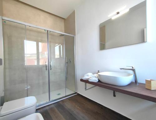シラクーサにあるNine Sweet Roomsのガラスのシャワーと洗面台を備えたバスルーム