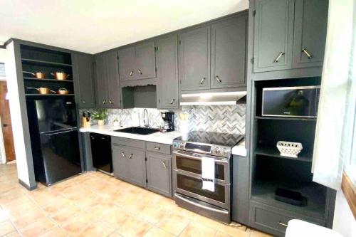 a kitchen with gray cabinets and a stove top oven at small rental for couple getaway in Dalton