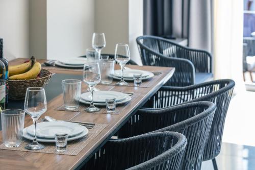 a wooden table with plates and wine glasses on it at Isla Villas & Suites in Balíon