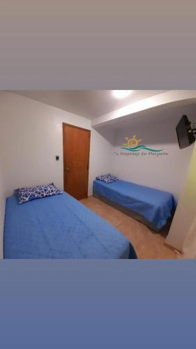 ParaguachiにあるPosada Villa Mayo Apartamento Familiar a 5 Min de Playa Parguitoのベッド2台とノートパソコンが備わる客室です。