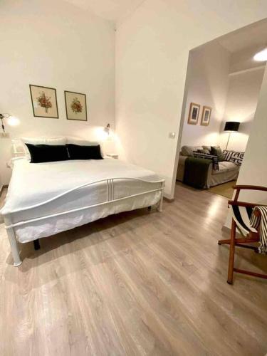 1 dormitorio blanco con 1 cama y sala de estar en Appartamento vicino al mare- IL GIACINTO, en Civitanova Marche