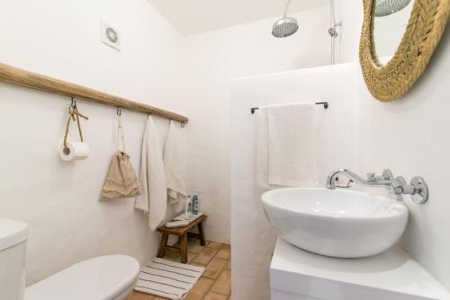 uma casa de banho branca com um lavatório e um WC em Casa Formosa - Serena Tradição em Santa Luzia