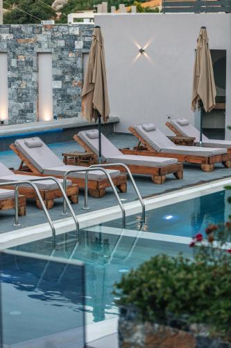 a swimming pool with lounge chairs and umbrellas at Isla Villas & Suites in Balíon