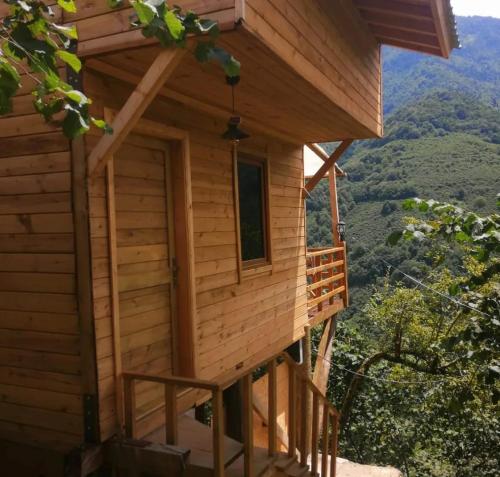 a log cabin with a porch and a window at YEŞİL BAHÇE EVLERİ 