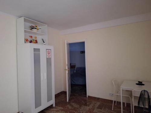 um quarto com uma porta que leva a um quarto com uma mesa em Pension El Dorado em Alicante