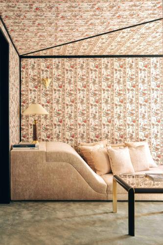 un salon avec un canapé en face d'un mur dans l'établissement Les Suites Cinabre, à Paris
