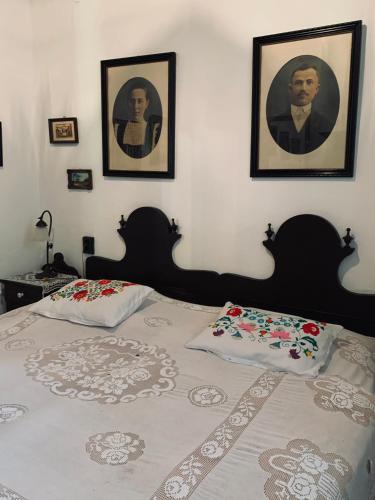 a bedroom with a bed with two pictures on the wall at Agriturismo Villa Carlotta in Szilvásvárad